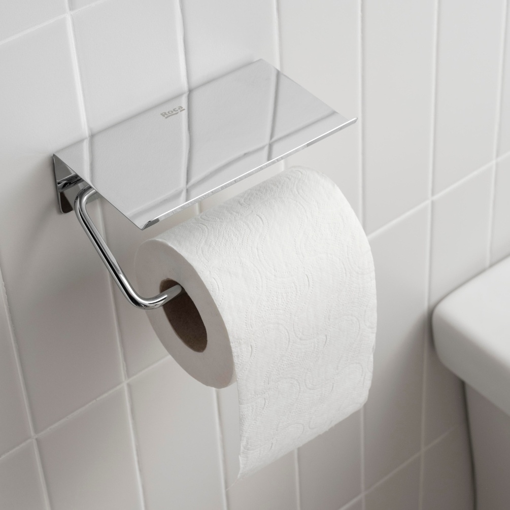 Lifestyle image of the Roca Sonata Chrome Toilet Roll Holder with Cover with toilet roll in use